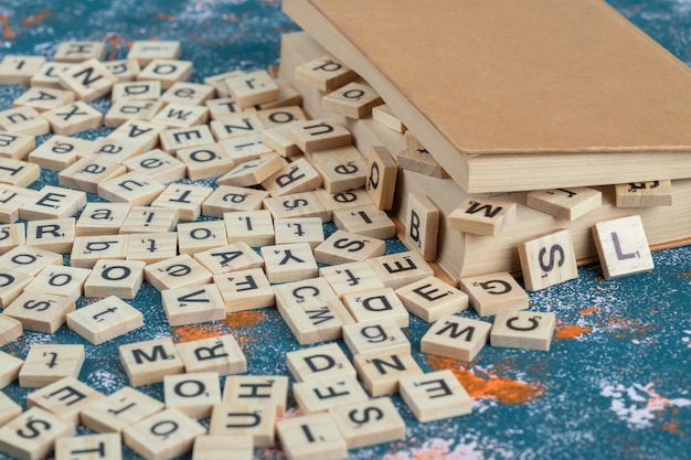 Wooden dice with letters on them between the pages of a book. 