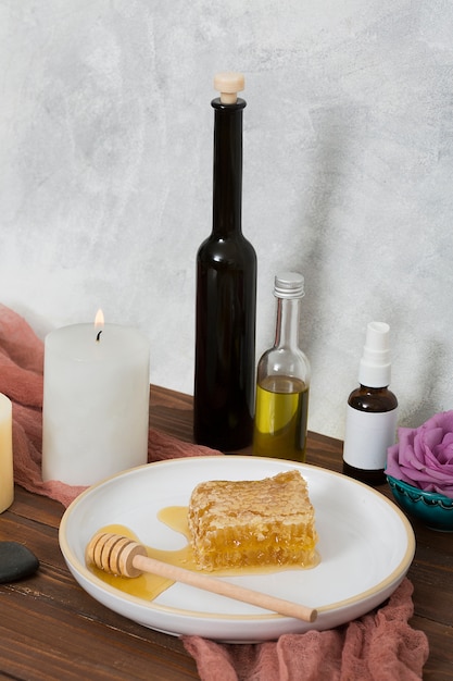 Wooden dipper and ceramic white plate with essential oil bottle on wooden table