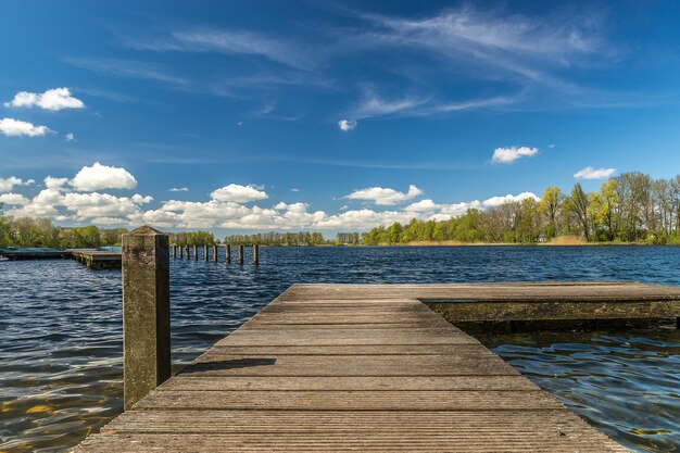 Wooden dock on the sea under the sunlight and a blue cloudy sky