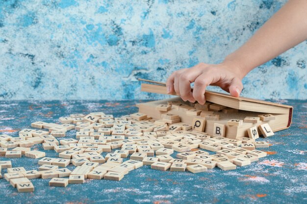 wooden domino keys with letter printed on them out of a wooden box