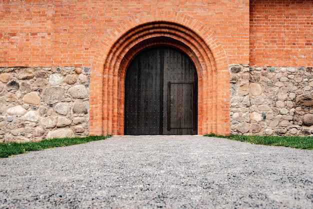 붉은 벽돌 성에서 나무로 되는 문.