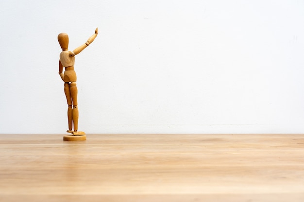 Free photo a wooden dummy mannequin in pose on a white wall