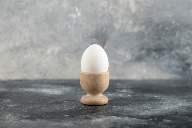 A wooden eggcup with boiled chicken egg . 