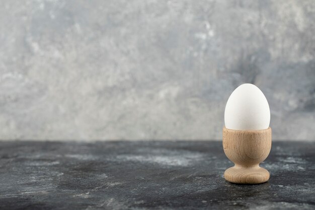 Деревянная чашка для яиц с вареным куриным яйцом.
