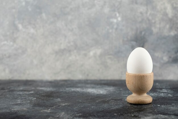 A wooden eggcup with boiled chicken egg . 