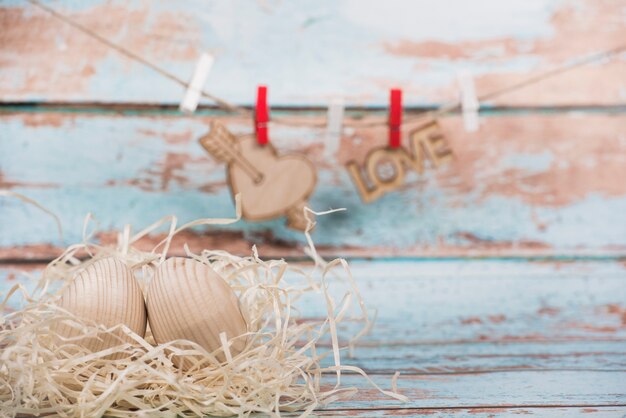 Wooden eggs in nest with heart and love inscription on rope 
