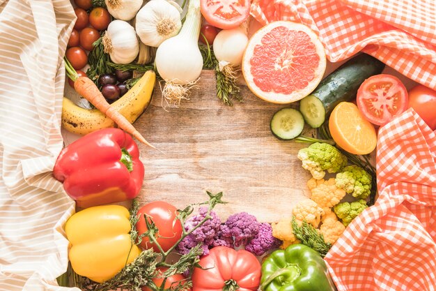 Wooden empty frame surrounded with vegetables and fruits