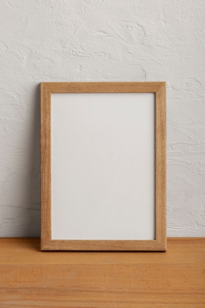 Wooden empty frame with white wall