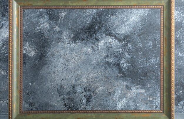 Wooden empty picture frame on marble.