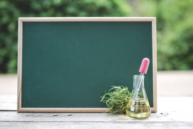 On the wooden floor there is hemp oil, hemp leaf And the green board is blank to put text.