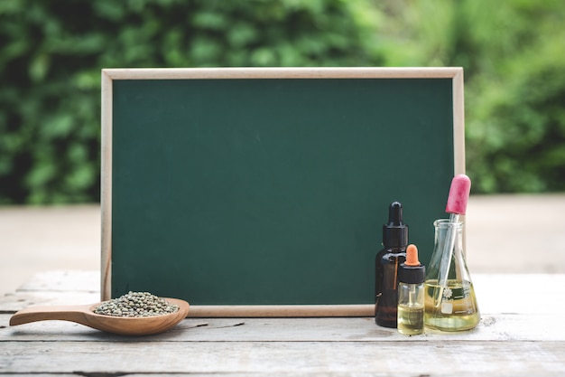 On the wooden floor there is hemp oil, hemp seeds. And the green board is blank to put text.