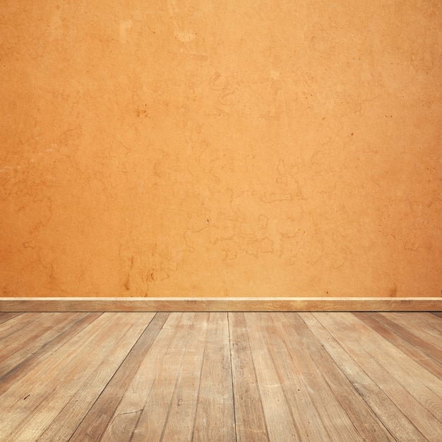 オレンジ色の壁の背景に木製の床