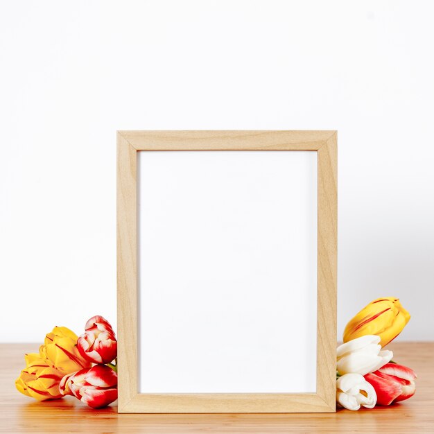 Wooden frame and tulips on white