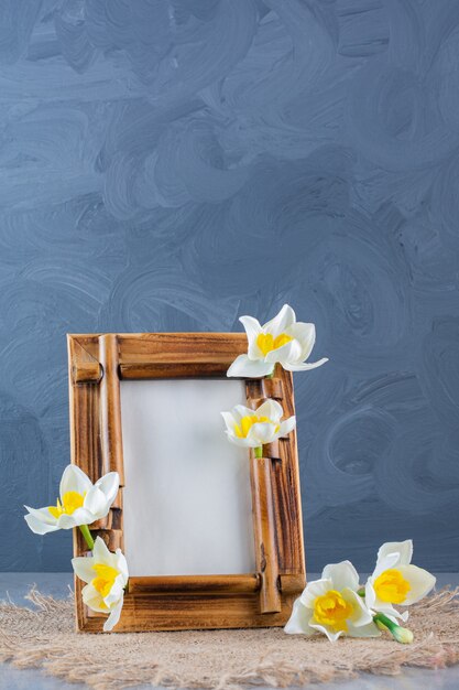 A wooden frame with white flowers on a sackcloth.