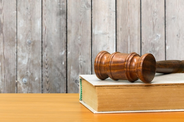 Wooden gavel and books on wooden table