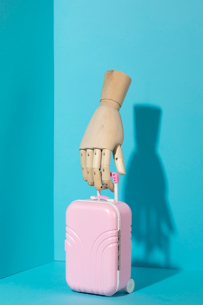Free photo wooden hand with luggage