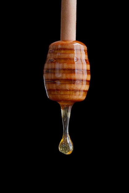 Wooden honey dipper with dripping honey