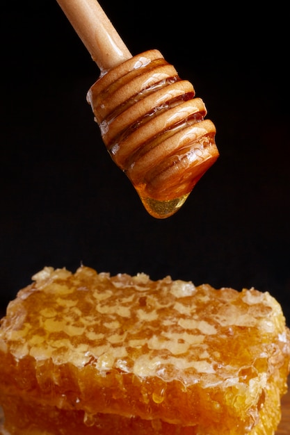 Foto gratuita mestolo di miele in legno con nido d'ape e cera d'api