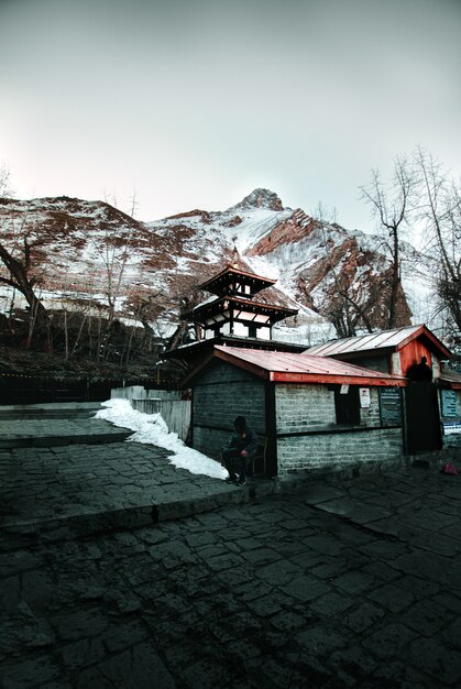 Wooden house against snowy hills in winter