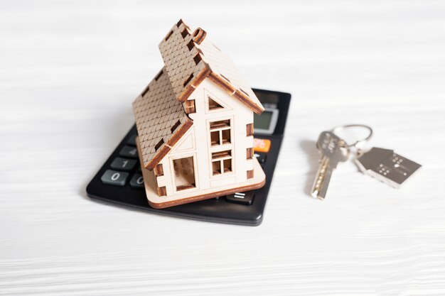 Wooden house on calculator