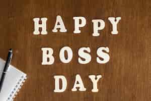 Free photo wooden inscription happy boss day on a wooden background