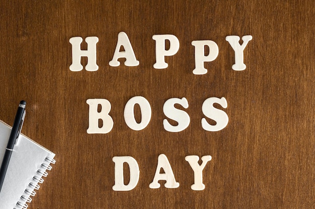 Wooden inscription happy boss day on a wooden background