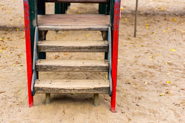 公園の砂の上の遊び場の木製のはしご
