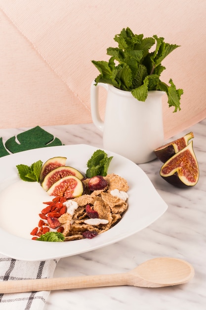 Free photo wooden ladle near healthy breakfast with mint leaves in jug on marble counter