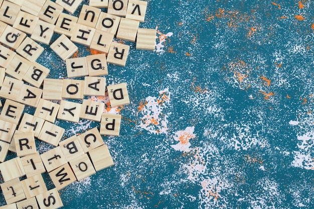 Free photo wooden letter dice on blue table.