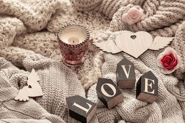 Wooden letters make up the word love over cozy knitted items. Valentine's Day holiday concept.