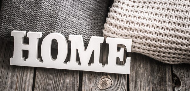 wooden letters with the inscription home and knitted sweaters