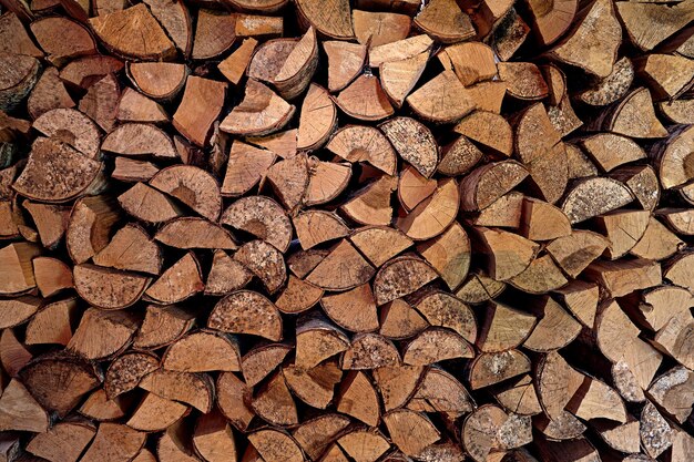 Wooden logs, beams, firewood, frame. A lot of wood. Wooden log wooden background. Fuel. Harvesting firewood for the winter. Logging