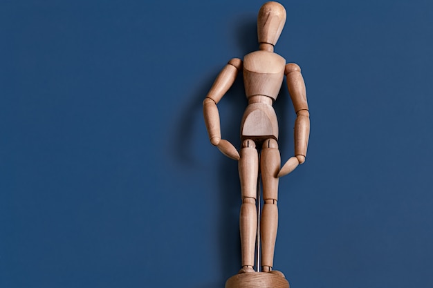 The wooden man figurine on blue.