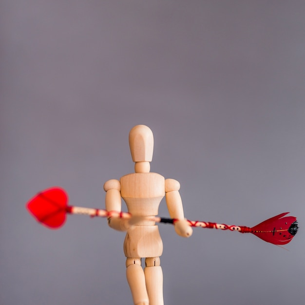 Wooden mannequin holding love arrow 