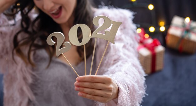 Wooden new years number in the hands of a girl close up.