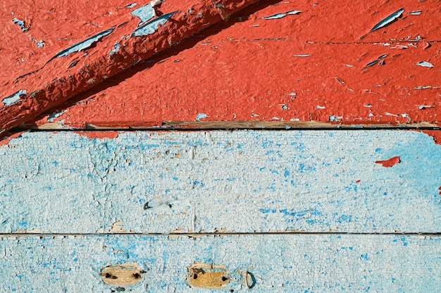 Wooden old boards with peeling red and blue paint background for design or social media