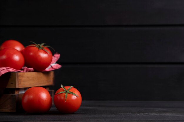 A wooden old box full of fresh red juicy tomatoes . High quality photo