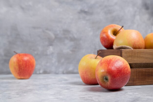 신선한 잘 익은 빨간 사과 과일의 전체 나무 오래 된 상자 대리석 배경에 배치. 고품질 사진