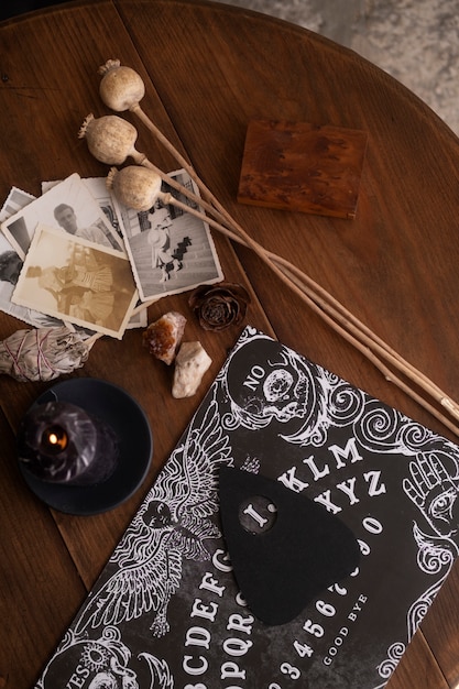 Wooden ouija board and old photos flat lay