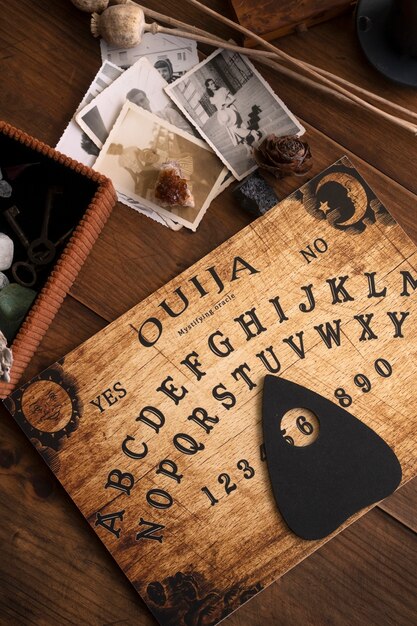 Wooden ouija board and old photos above view