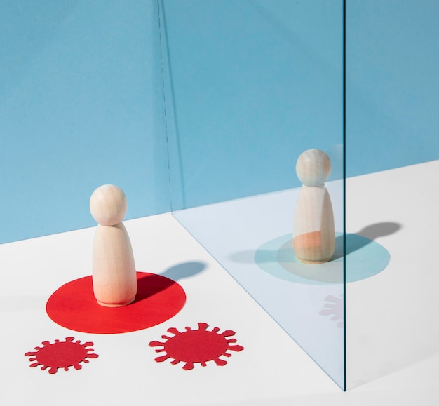Wooden pawns with glass divider during coronavirus pandemic