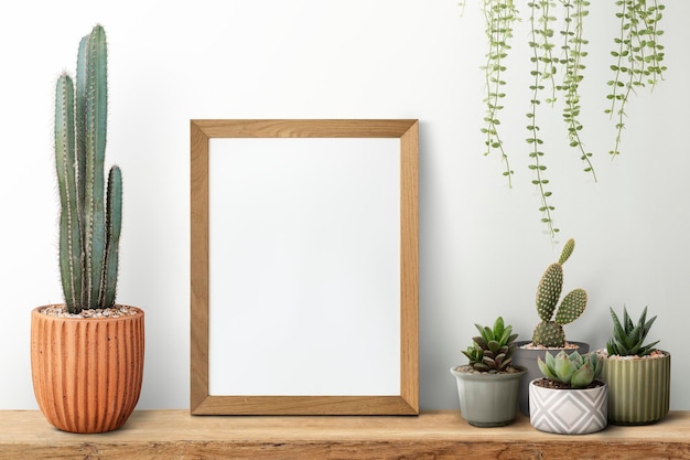 Free photo wooden picture frame on a shelf with cactus