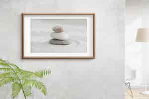 Free photo wooden picture frame with zen stones photo on the wall interior concept