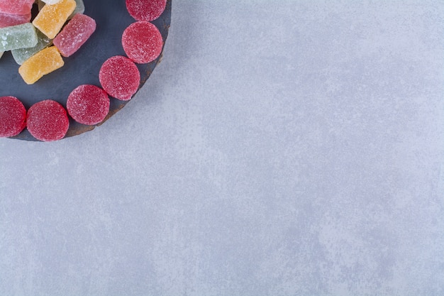 Un pezzo di legno pieno di caramelle di gelatina zuccherate colorate