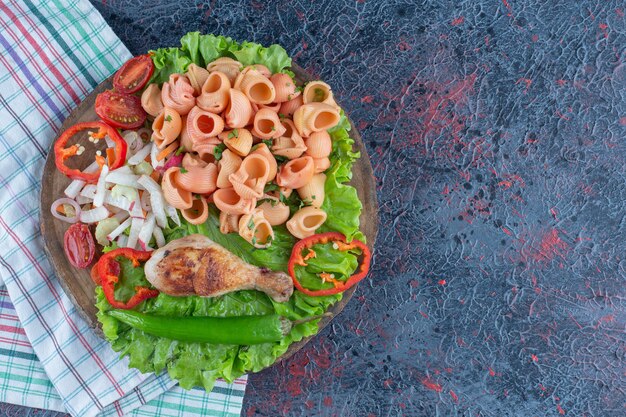 야채 샐러드와 함께 맛있는 닭 다리 고기의 나무 조각.