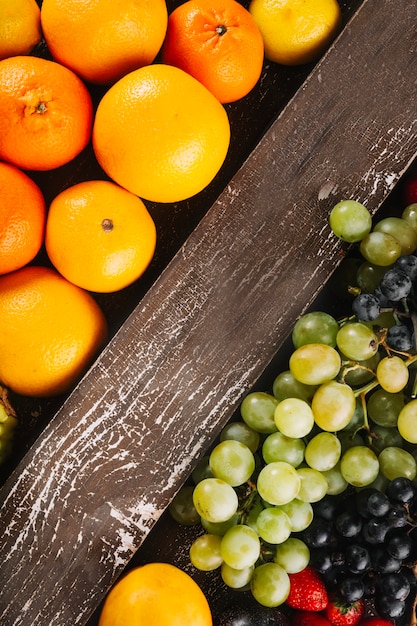 Wooden plank between citruses and grape