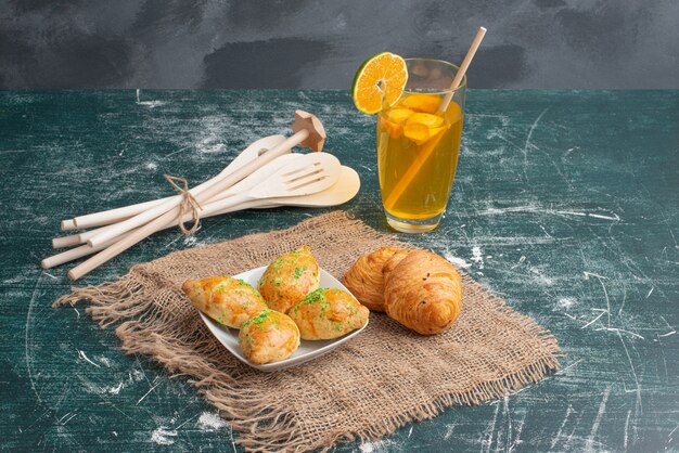 Wooden plate of bakery with kitchen tools on marble table .