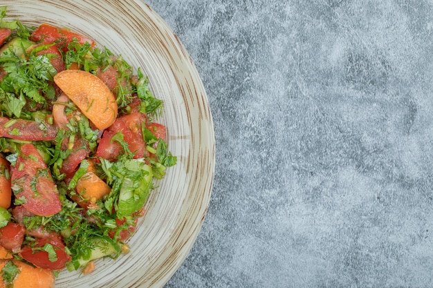 Foto gratuita un piatto di legno di deliziosa insalata di verdure.