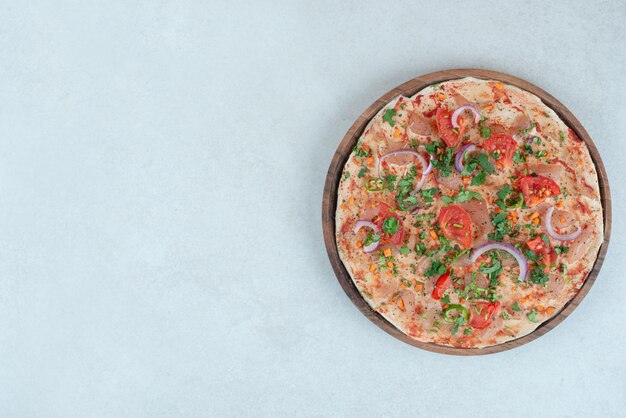 얇게 썬 토마토와 양파를 곁들인 피타 빵 나무 접시.