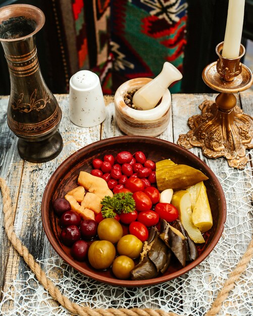 Wooden plate with pickles on the table